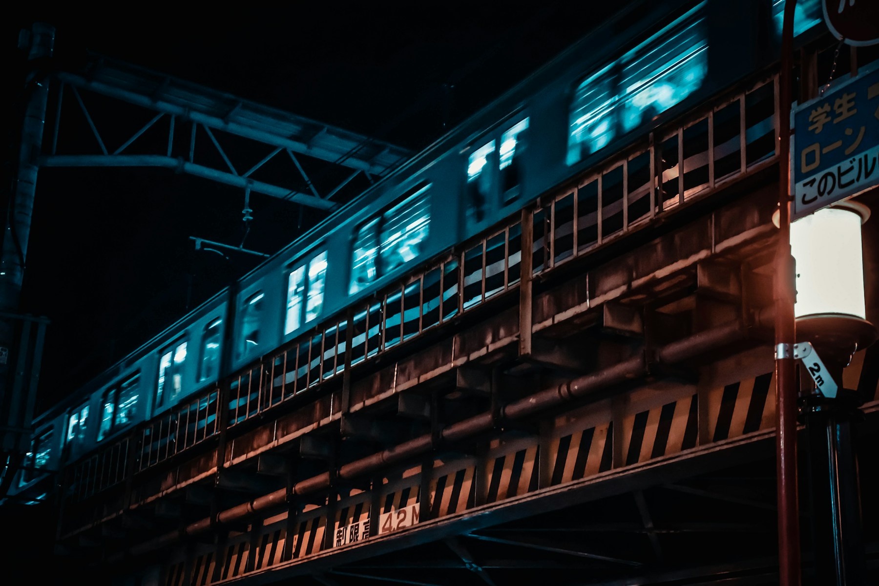 A passenger train waiting at a station after dark